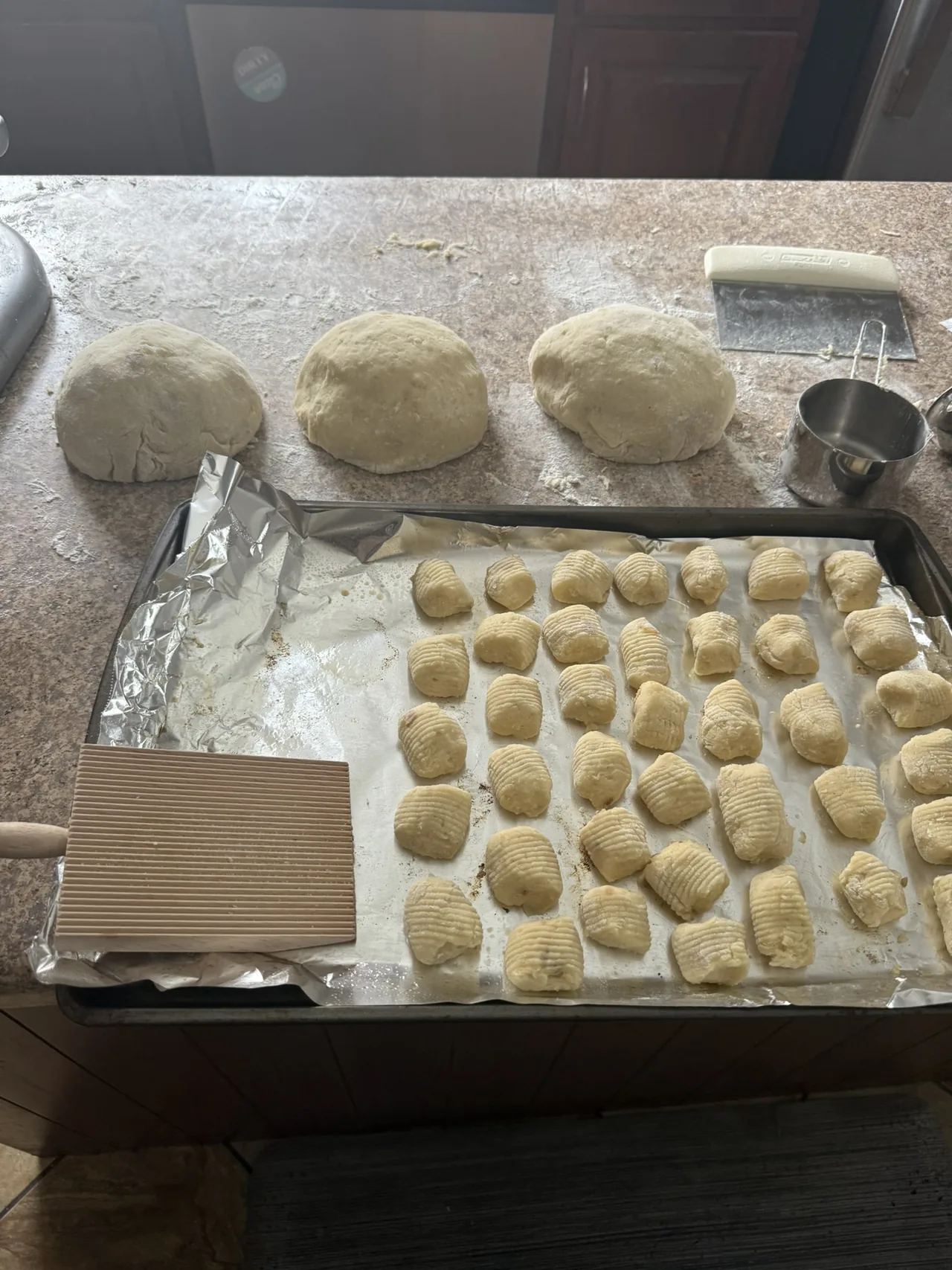 Handmade gnocchi in progress with dough, shaped pieces, flour, and bench tools